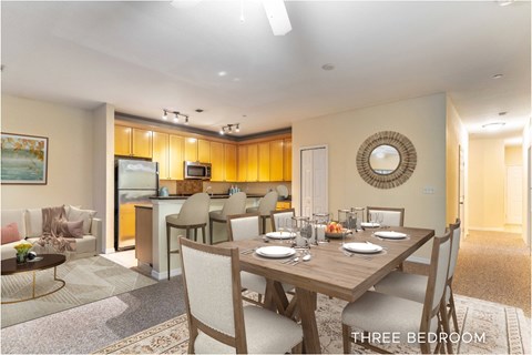 A dining room with a table set for three.