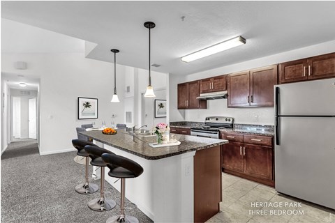 A kitchen with a bar area and a refrigerator.