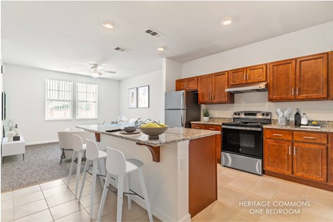 A kitchen with white chairs and a marble countertop.