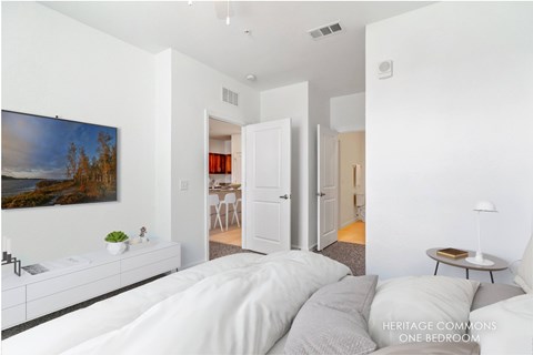 A bedroom with a large bed and a painting on the wall.