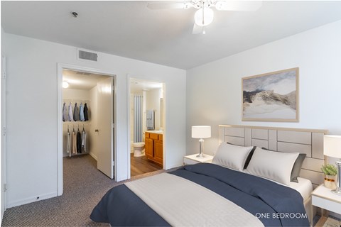 A bedroom with a large bed and a painting on the wall.