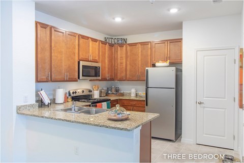 A kitchen with wooden cabinets and a granite countertop.
