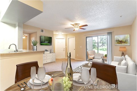 A well-lit one bedroom apartment with a dining table set for two.