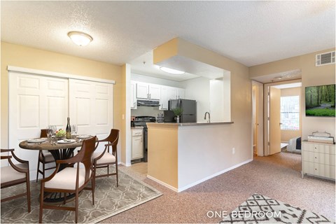 A kitchen with a dining table and chairs in the middle of the room.