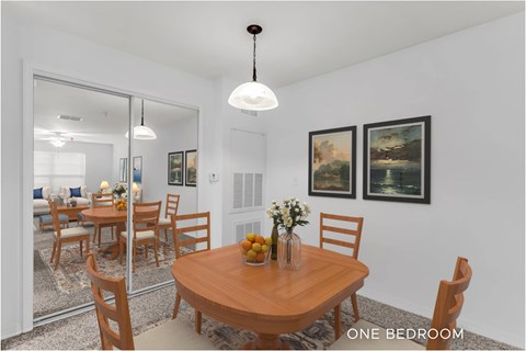 A dining room with a wooden table and chairs.