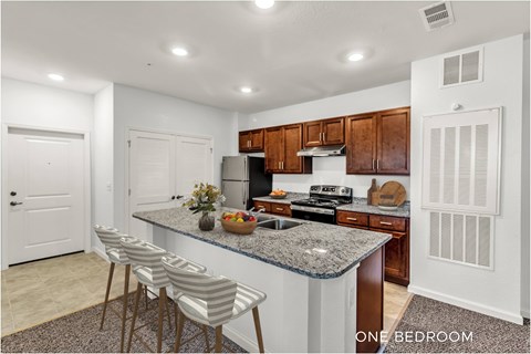 A kitchen with granite countertops and wooden cabinets.