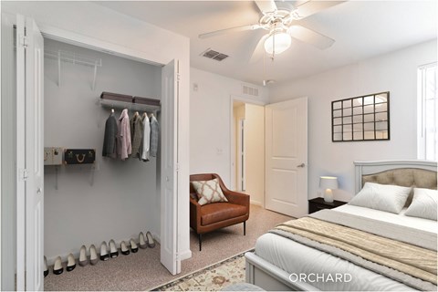 A bedroom with a large bed, a chair, and a closet.