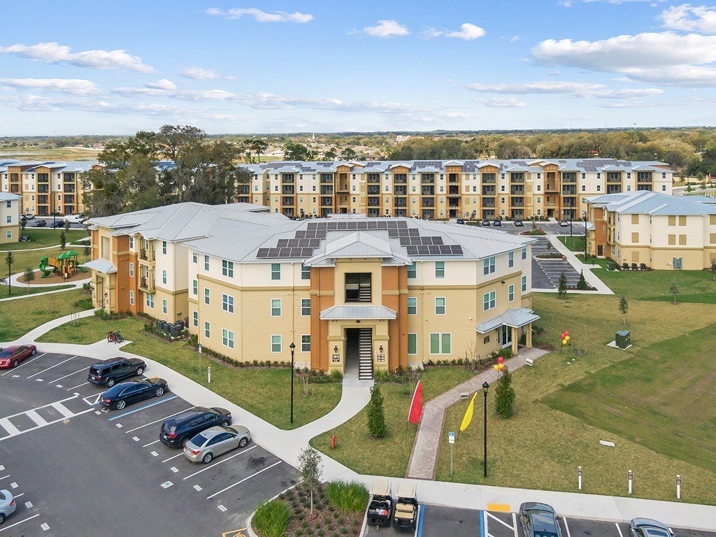 an aerial view of a building with a bridge over a parking lot