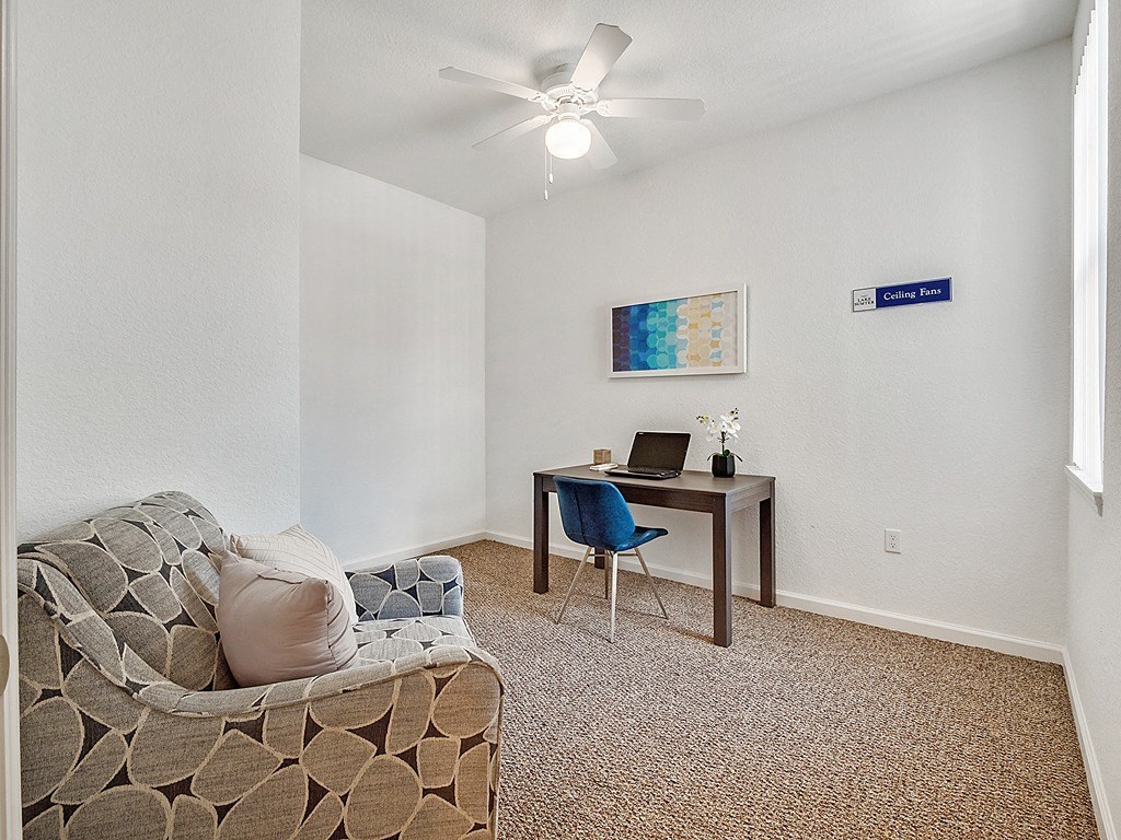 a living room with a couch and a desk with a laptop