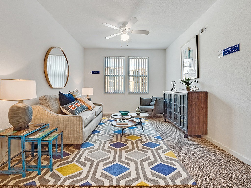 a living room with a couch and a ceiling fan