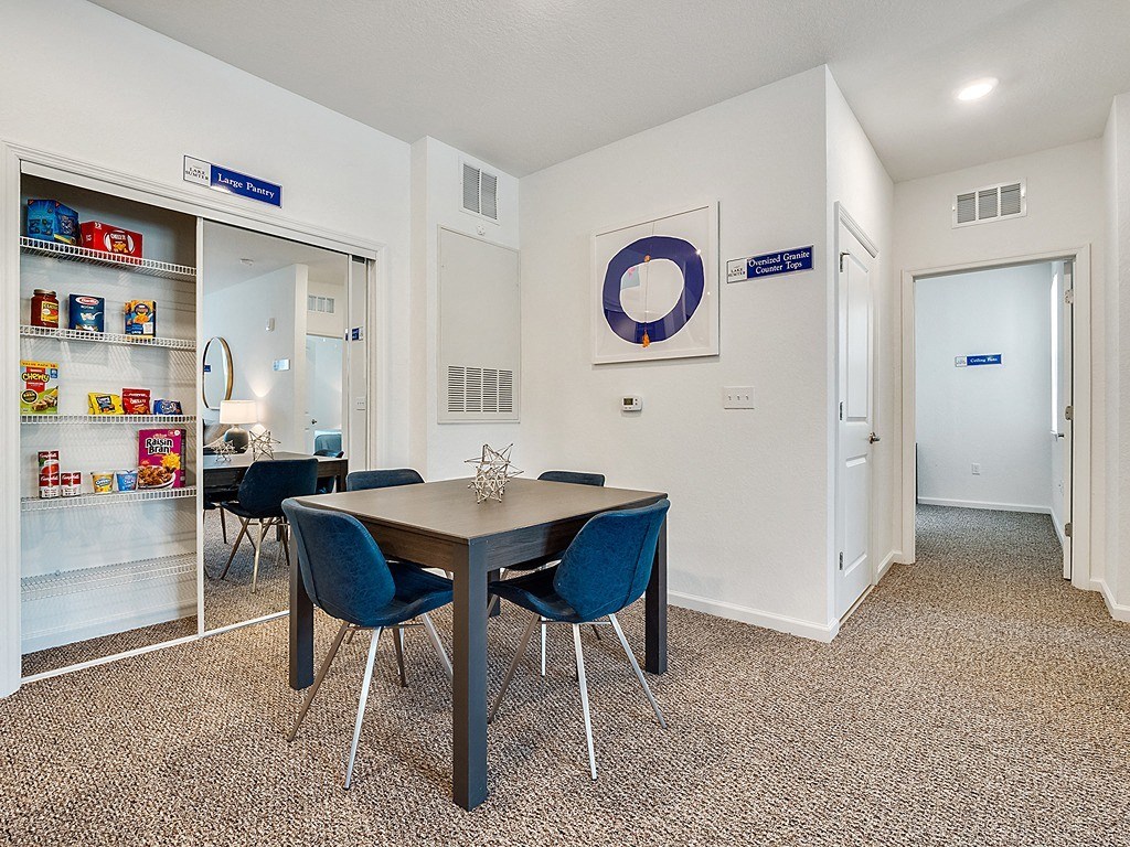 a dining area with a table and chairs and a door to the kitchen