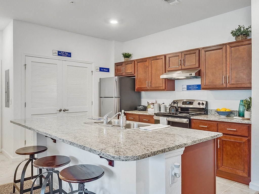 a kitchen with a marble counter top and wooden cabinets