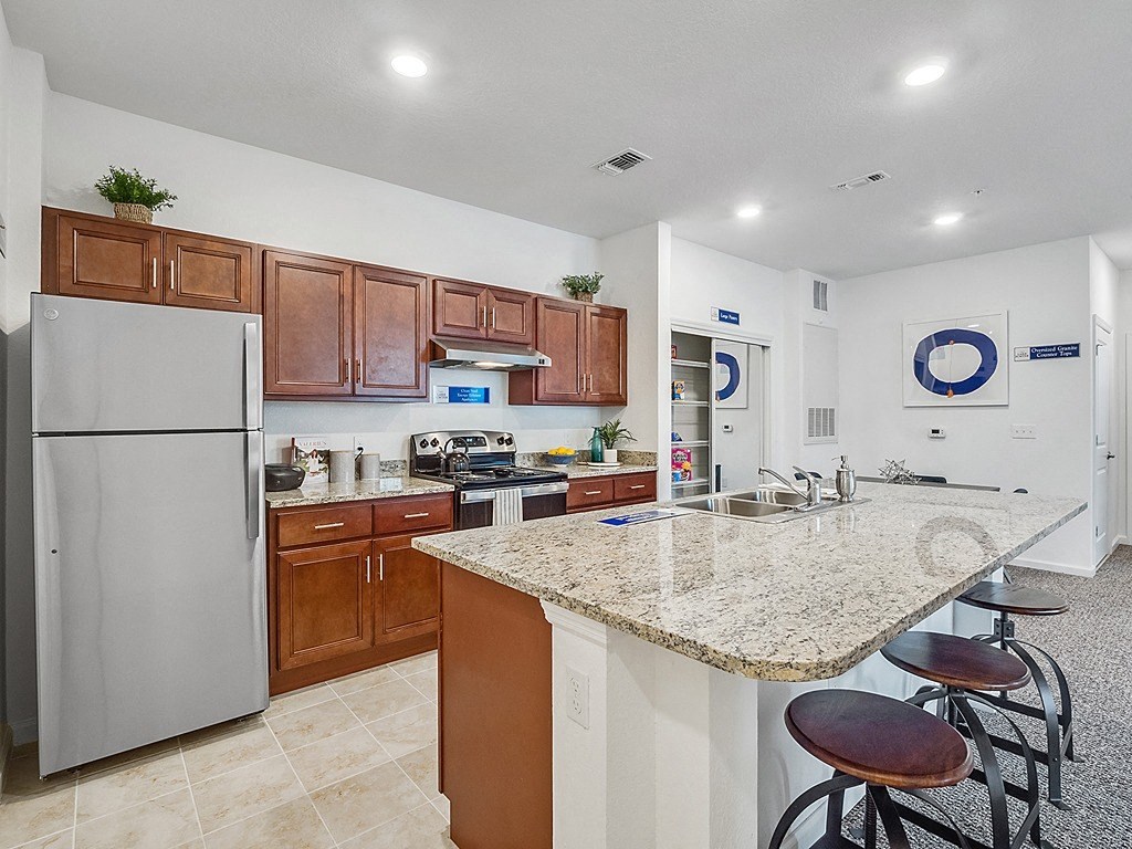 a kitchen with a granite counter top and a stainless steel refrigerator