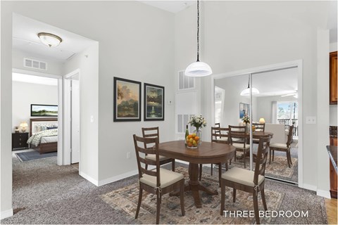 A dining room with a table set for four.
