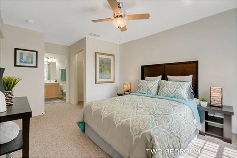 A bedroom with a bed and a ceiling fan.