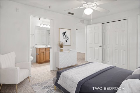 A bedroom with a large bed and a chair.
