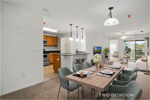 A dining room with a table set for two and chairs around it.