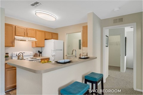 A kitchen with a bar stool in front of it.