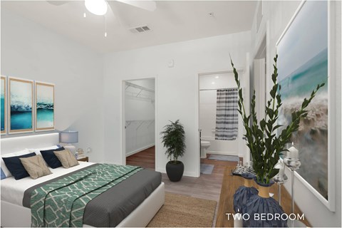 A bedroom with a bed, a plant, and a painting on the wall.