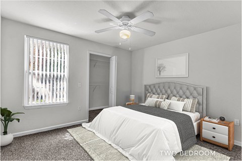 A bedroom with a bed, nightstand, and window with blinds.
