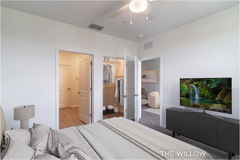 A bedroom with a large bed and a flat screen TV mounted on the wall.