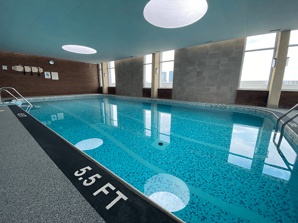 a large swimming pool in a room with windows