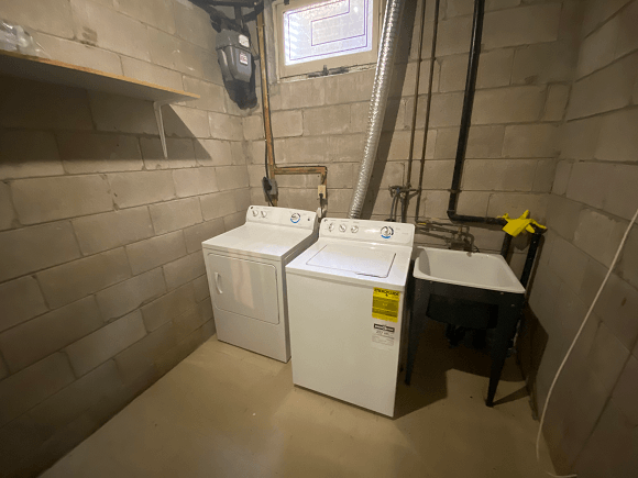 a laundry room with two washing machines and a sink