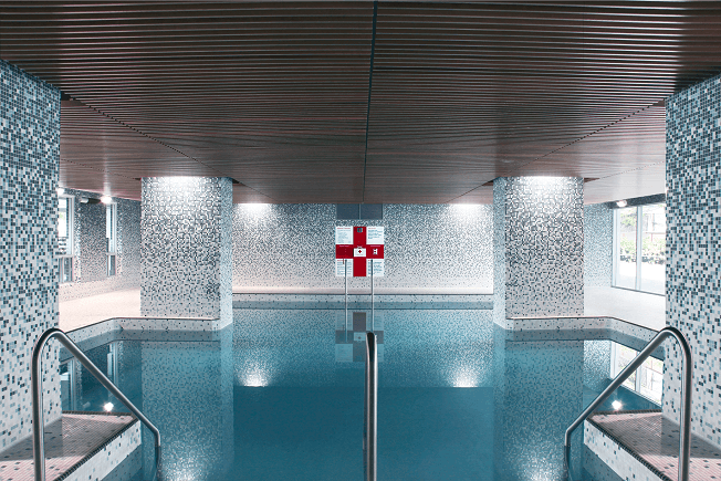 a swimming pool with a red cross on the wall