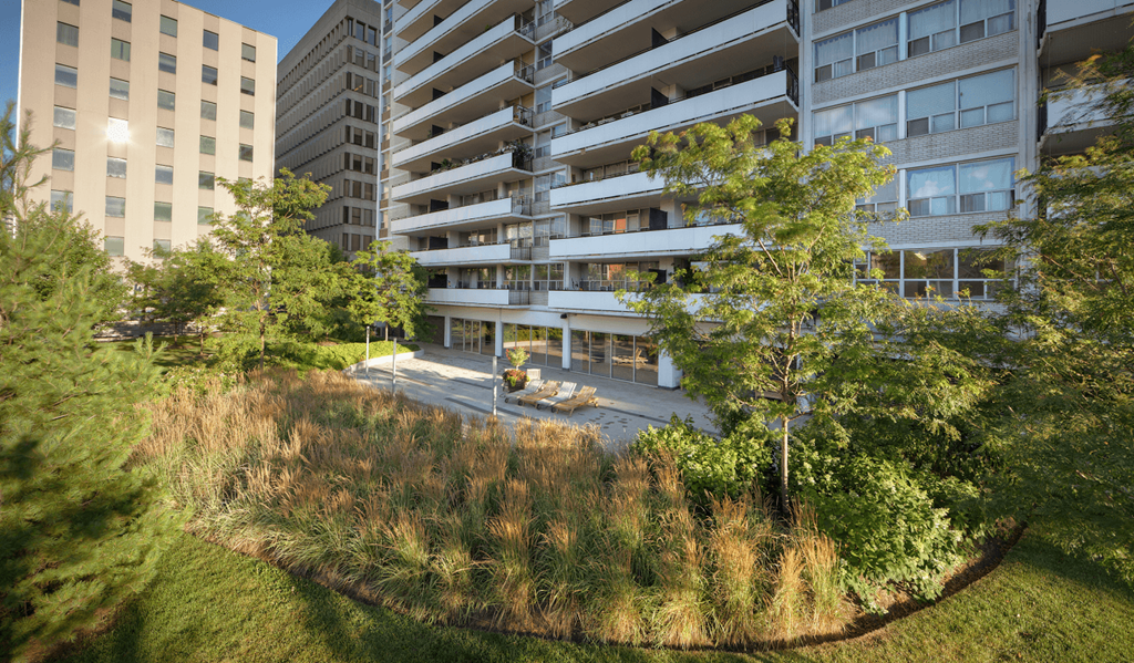 an aerial view of an apartment building with trees and grass