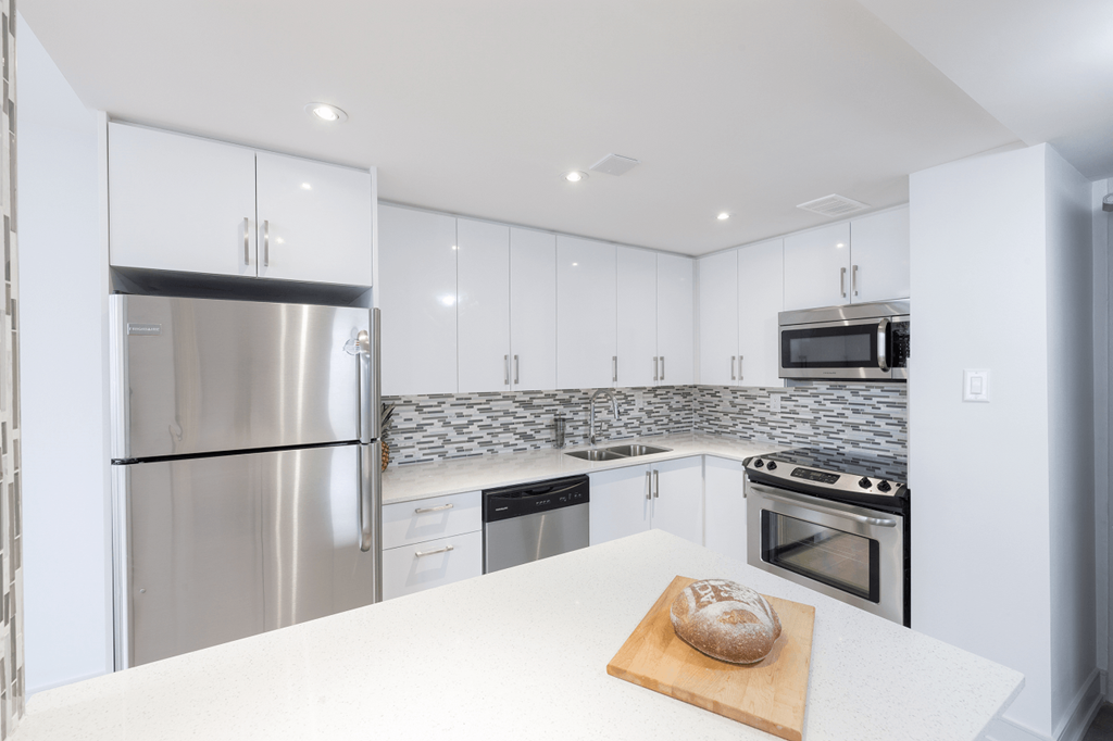 a kitchen with white cabinets and stainless steel appliances