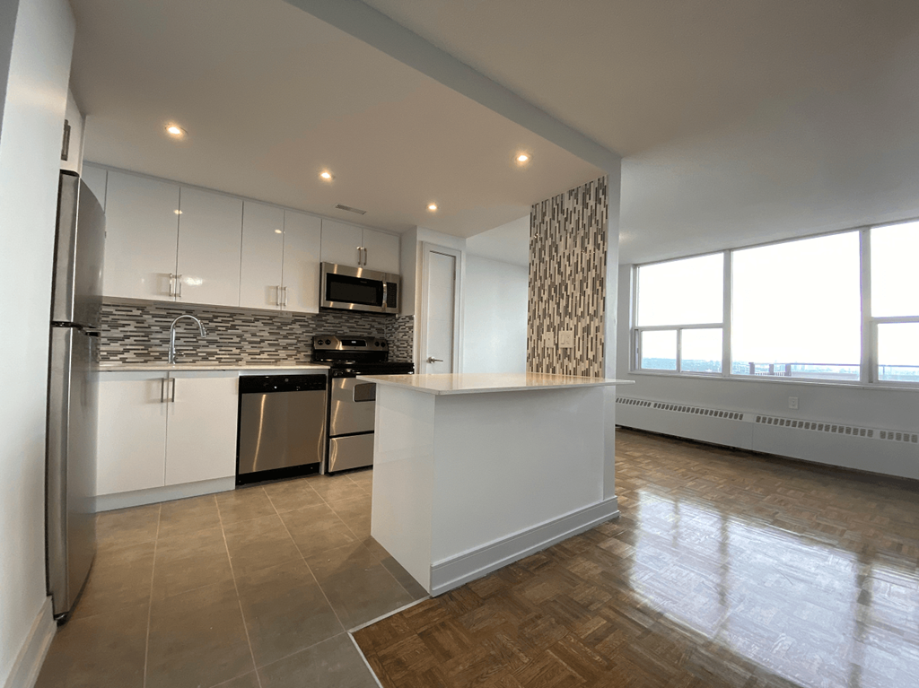 an open kitchen and living room with a large window
