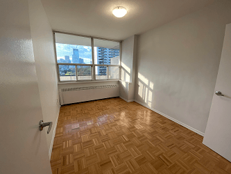 an empty living room with wood flooring and a window