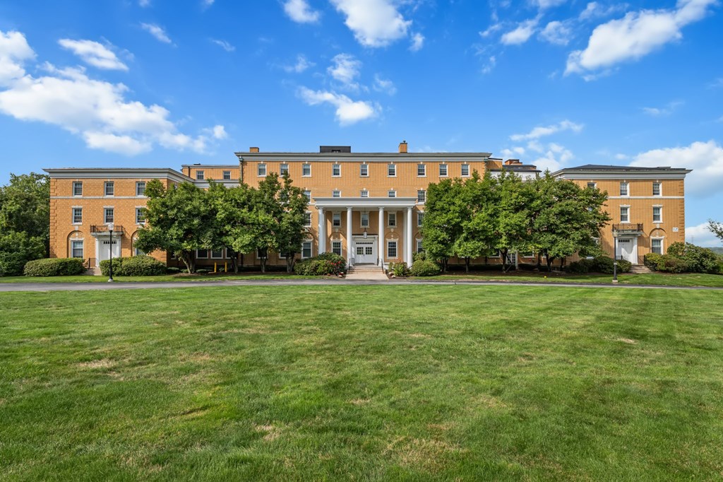 A large building with a green lawn in front.