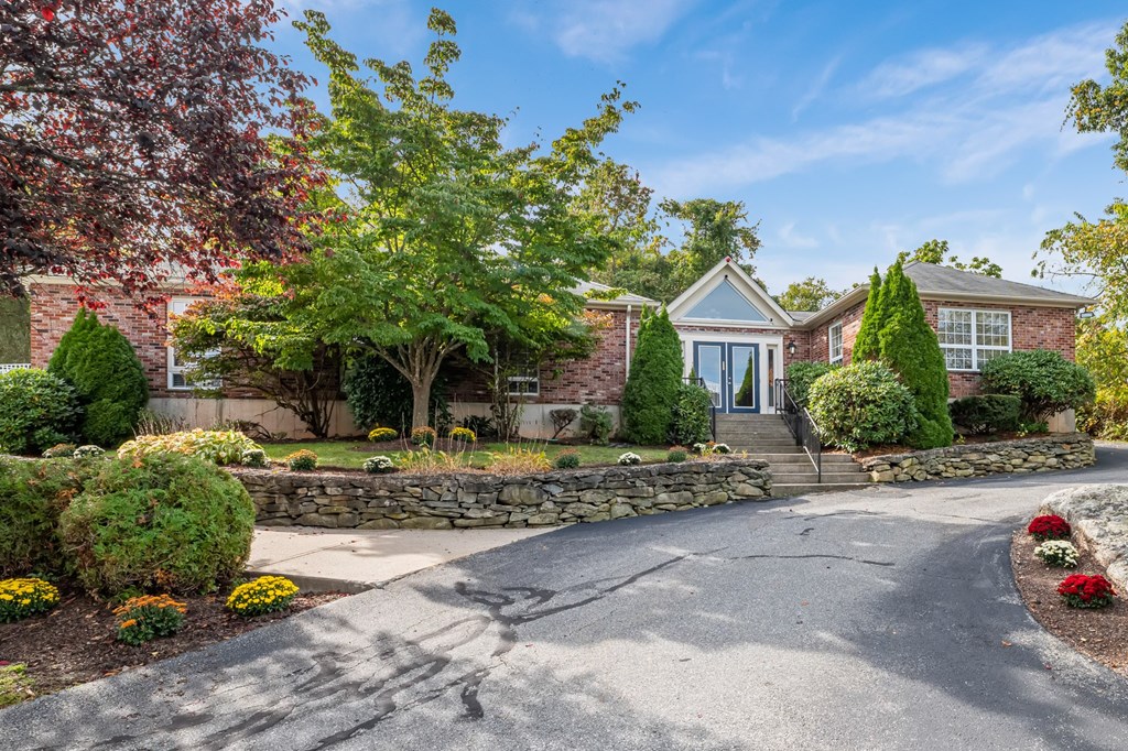 A house with a driveway and a stone wall.