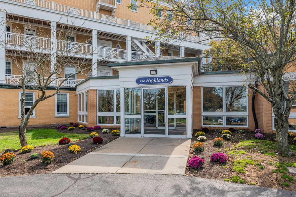 The Highlands building entrance with a flower bed in front.