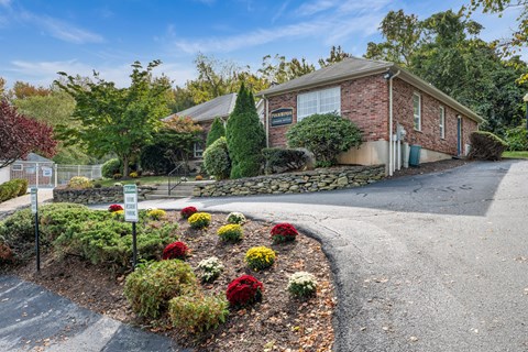 A small brick building with a sign in front of it.