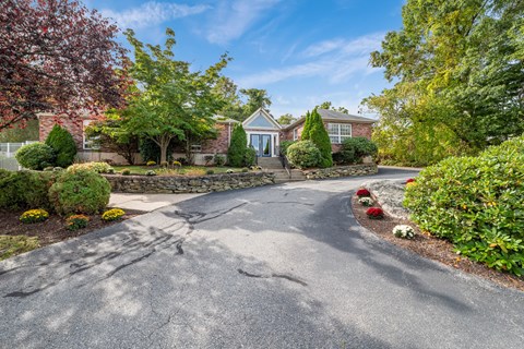 A house with a driveway and a stone wall.