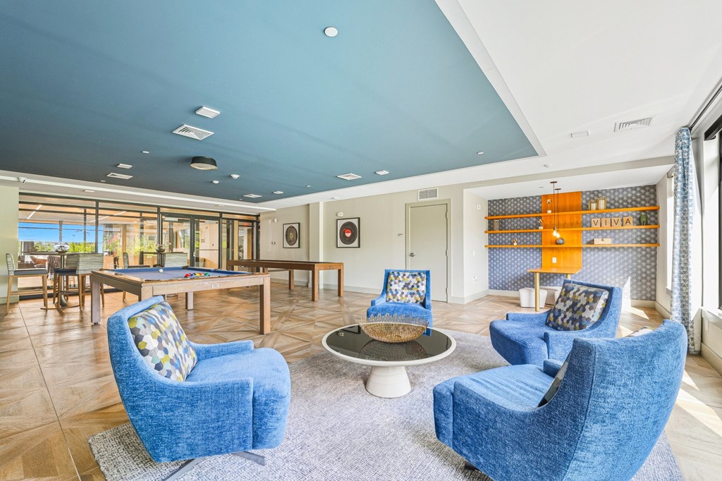 A living room with blue chairs and a wooden coffee table.