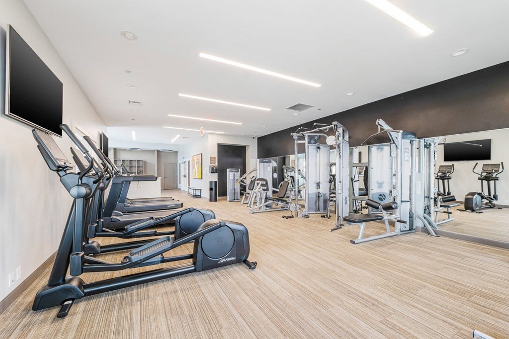 A gym with treadmills, weights, and exercise machines.
