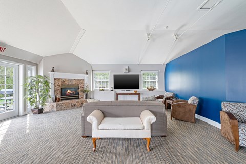 A living room with a grey couch and a fireplace.