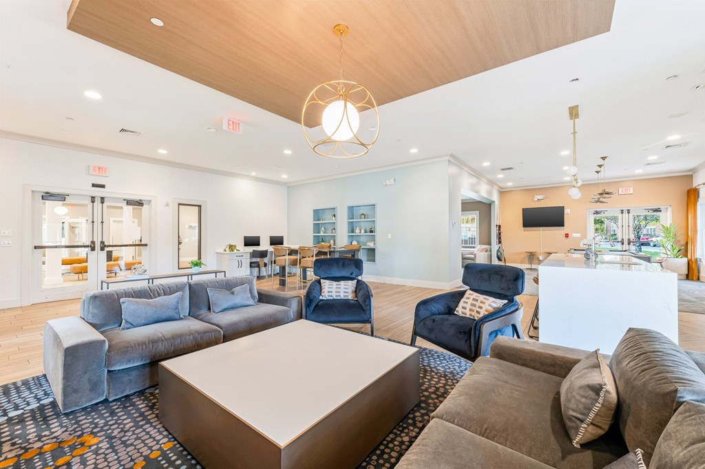 A large, modern living room with a variety of seating options and a flat-screen TV.