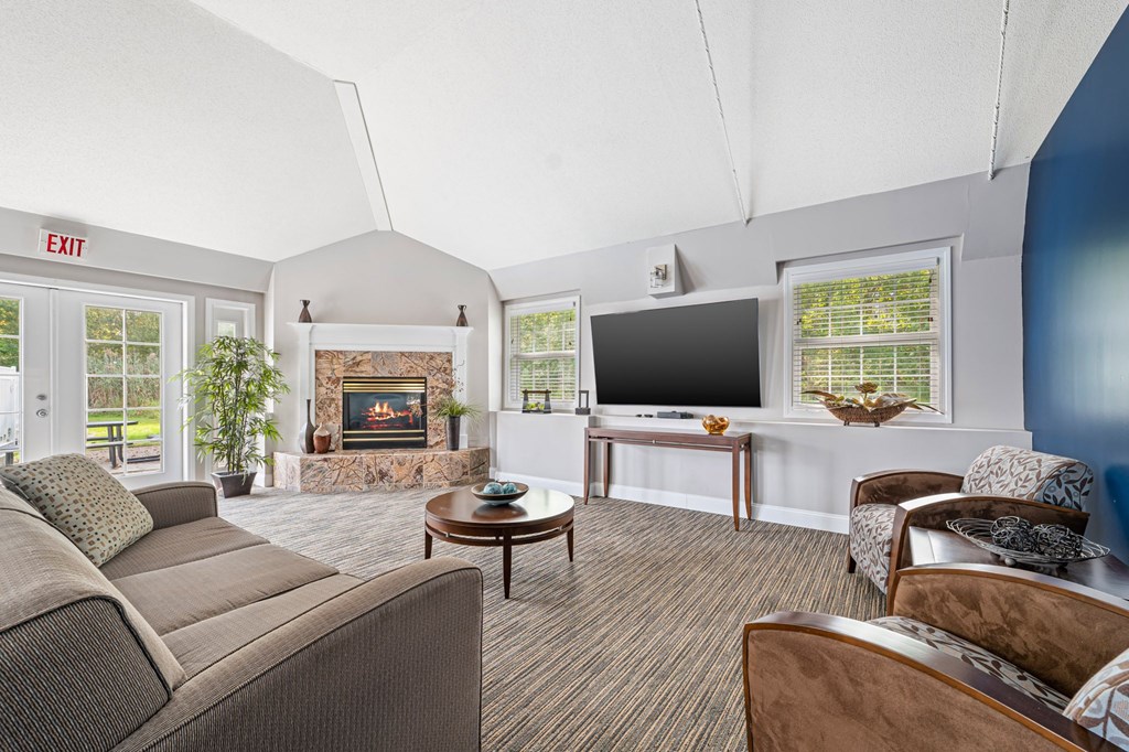 A living room with a couch, chairs, and a fireplace.