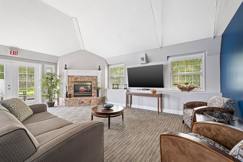 A living room with a couch, chairs, and a fireplace.