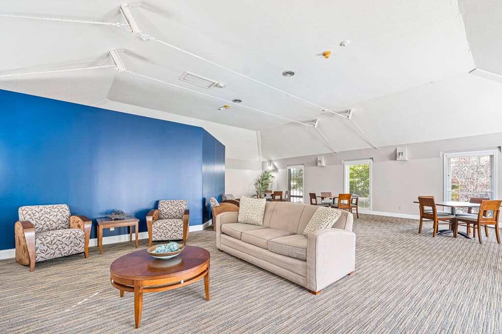 A living room with a couch, chairs, and a coffee table.