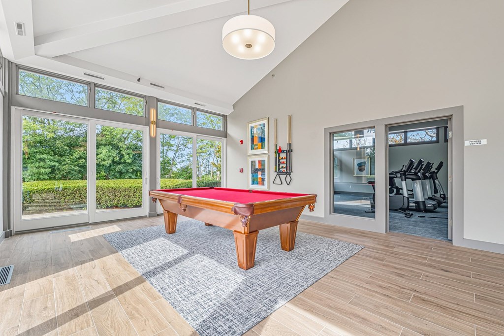 A room with a pool table and a red cloth on it.