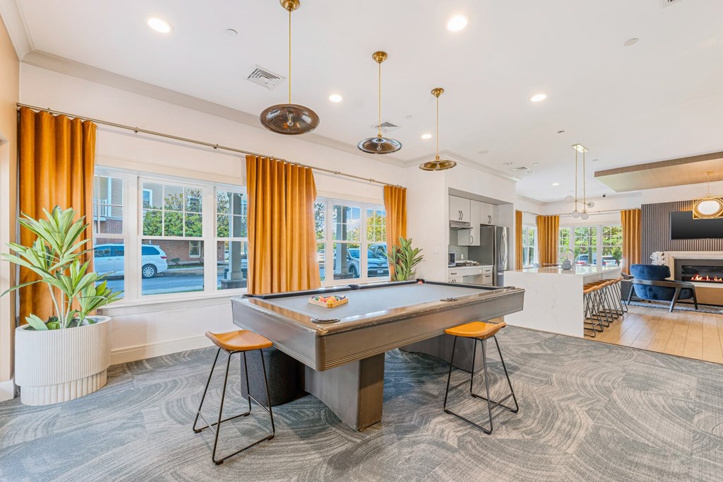 A room with a pool table and a fireplace.