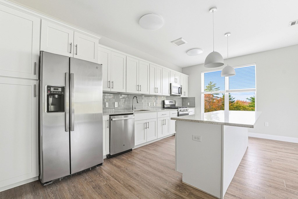A modern kitchen with stainless steel appliances and white cabinets.
