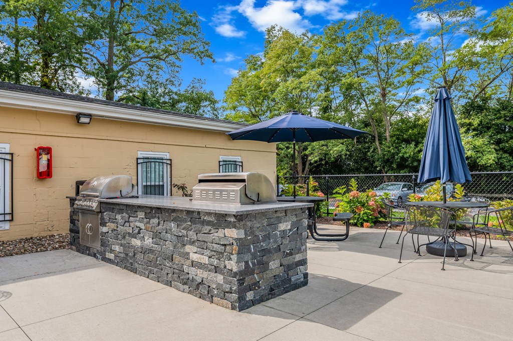 A stone barrier in front of a yellow building.