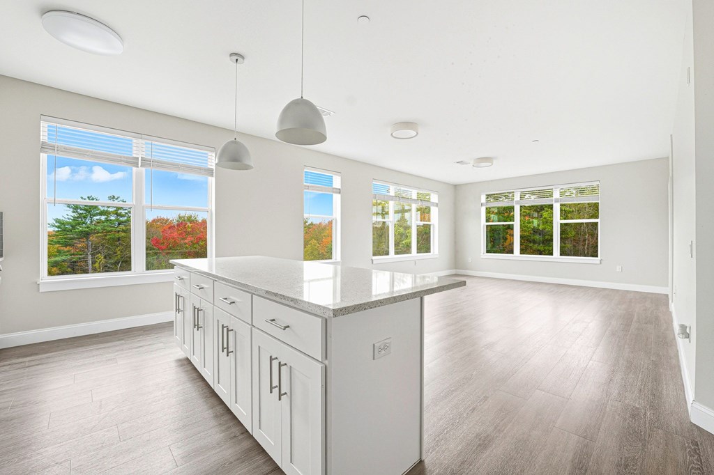 A spacious kitchen with white cabinets and a large island.