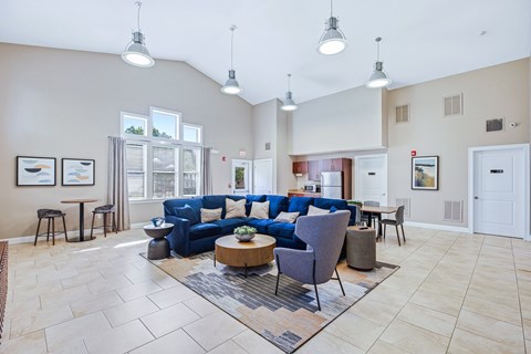 A spacious living room with a blue sofa and a coffee table.
